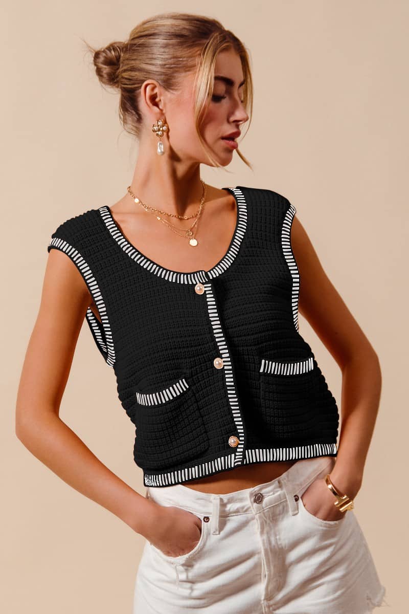 Black vest for women sweater with white trim and buttons worn with white shorts by a woman