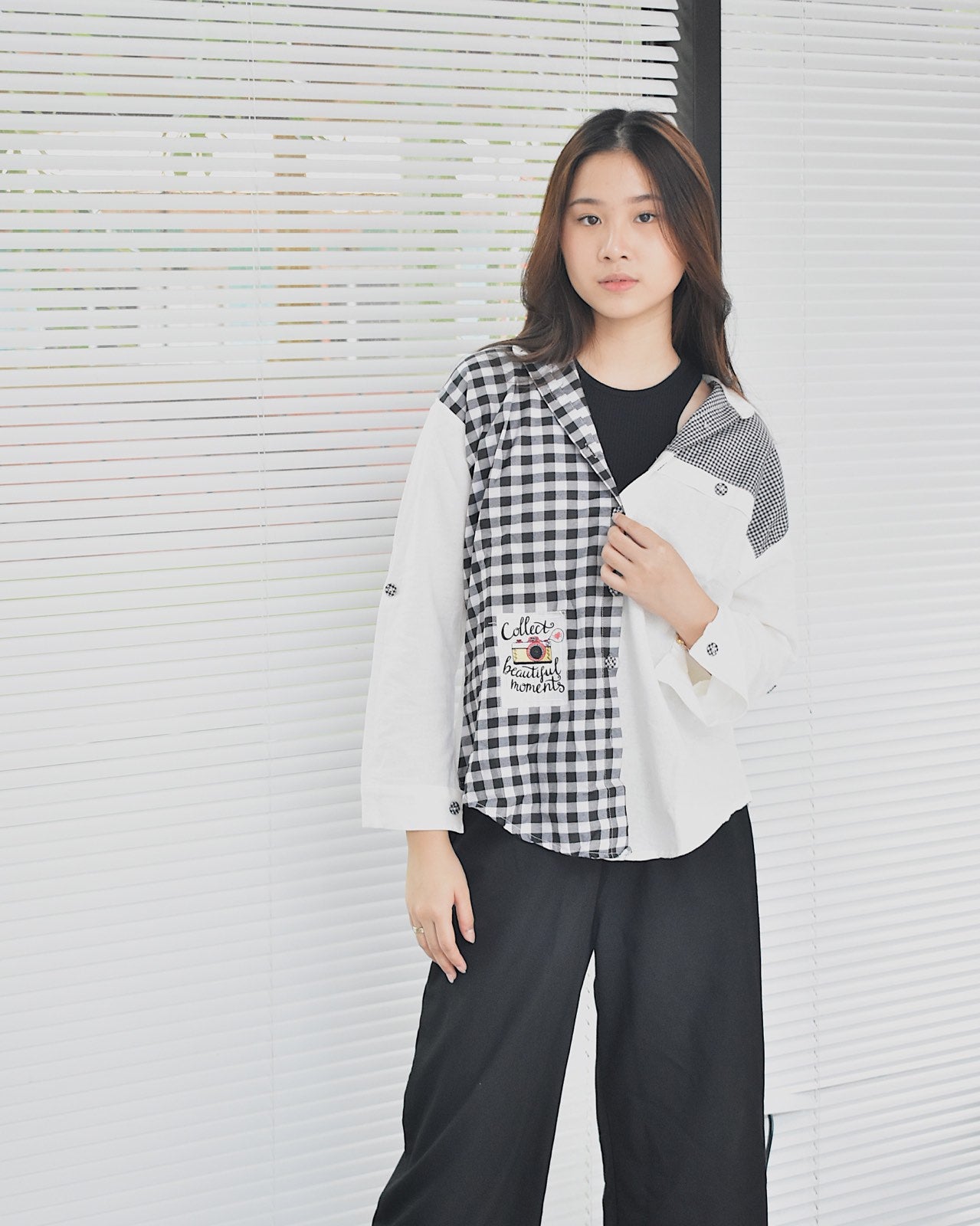 Young woman wearing an affordable women's fashion shirt with black and white checkered and solid patterns
