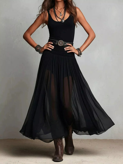 Trendsi black maxi dress with sheer flowing skirt and sleeveless fitted top styled with belt and boots