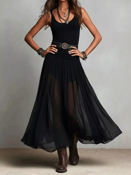Trendsi black maxi dress with sheer flowing skirt and sleeveless fitted top styled with belt and boots
